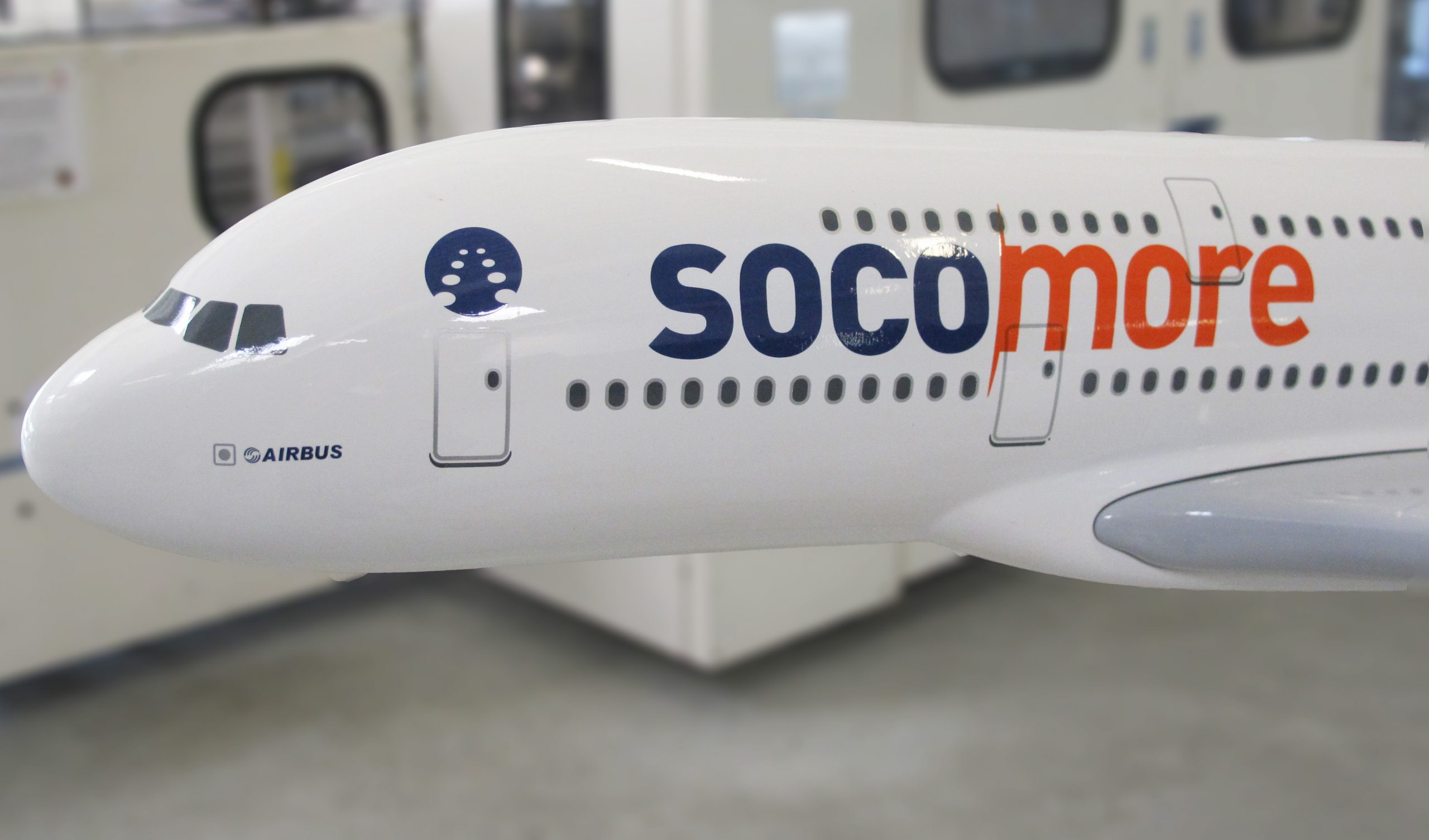 Un avion blanc Airbus, avec le logo SOCOMORE