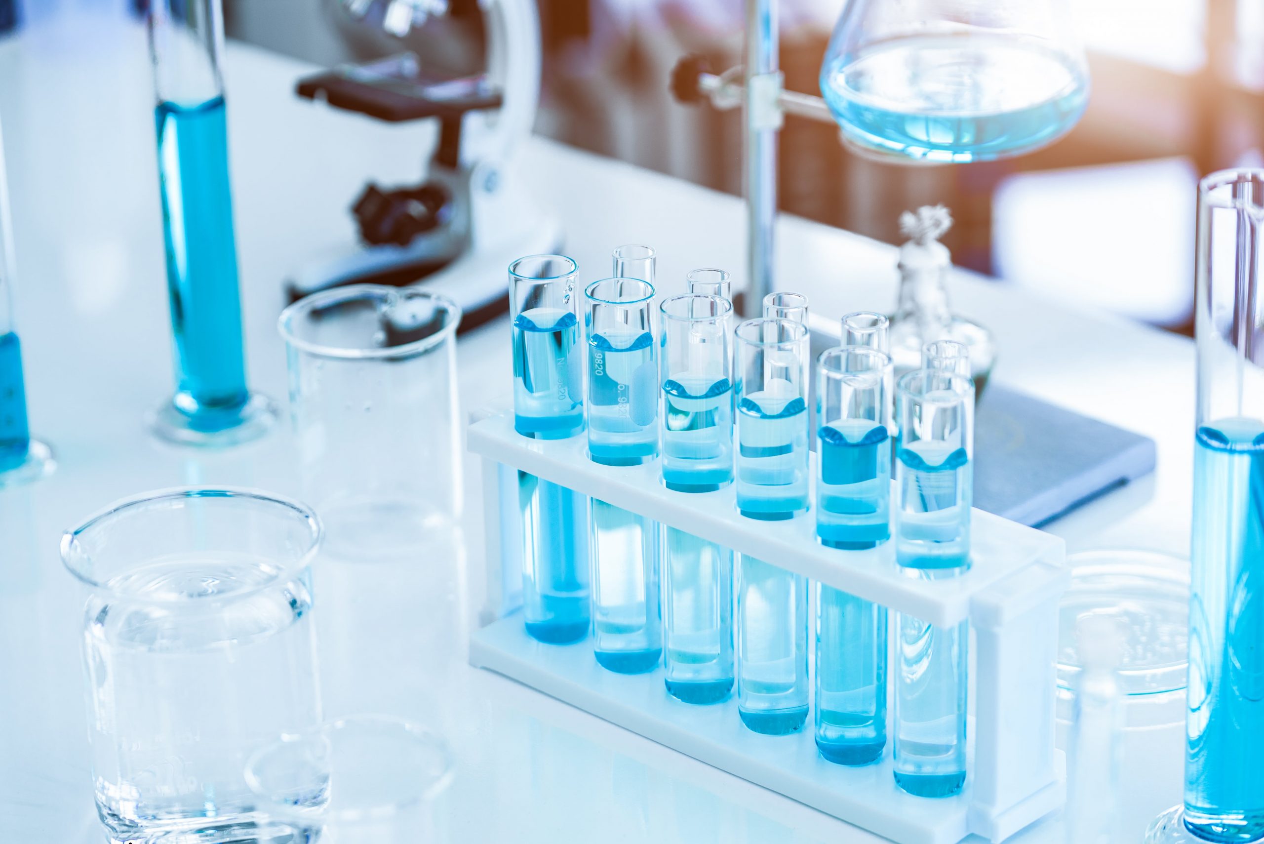 des tubes à essais avec une coloration bleue sur un plan de travail en laboratoire